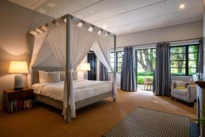 a bedroom with a canopy bed and a chair at Goatfell - Nuwara Eliya in Kandapola
