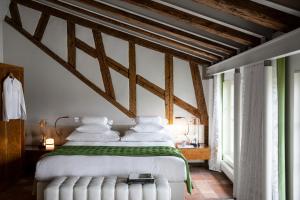 a bedroom with a white bed with a green blanket at Storchen Zürich - Lifestyle boutique Hotel in Zurich