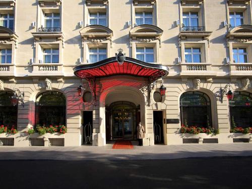 a woman standing in front of a building at Hôtel Le Royal Monceau Raffles Paris in Paris