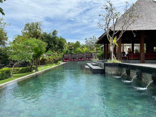 a pool of water in front of a building at La Reserve 1785 Canggu Beach in Canggu