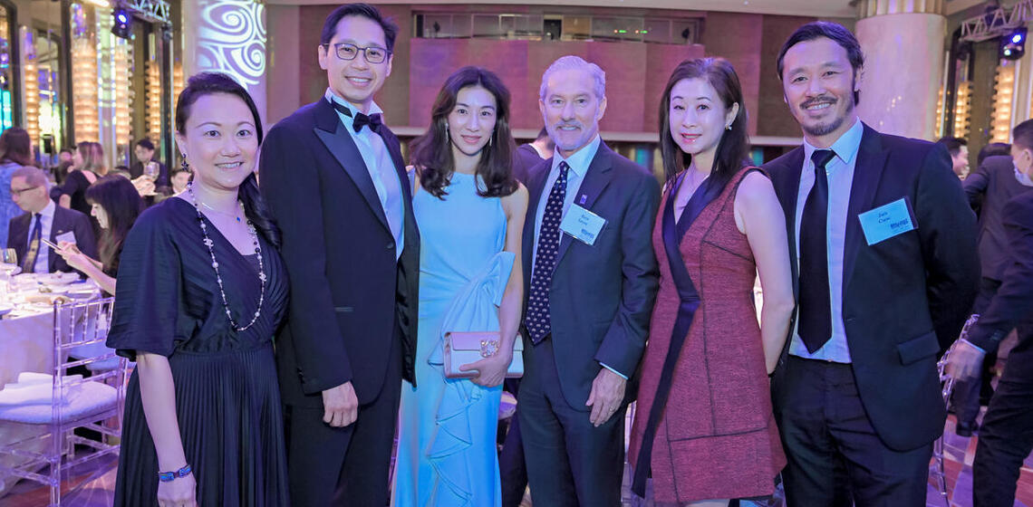 rich lyons posing with a group of people at a dinner