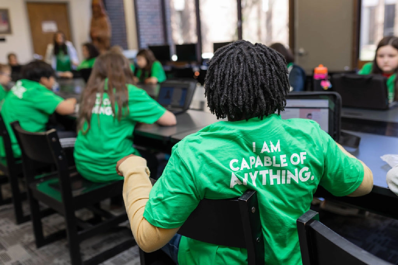 Students in computer lab wearing matching green shirts