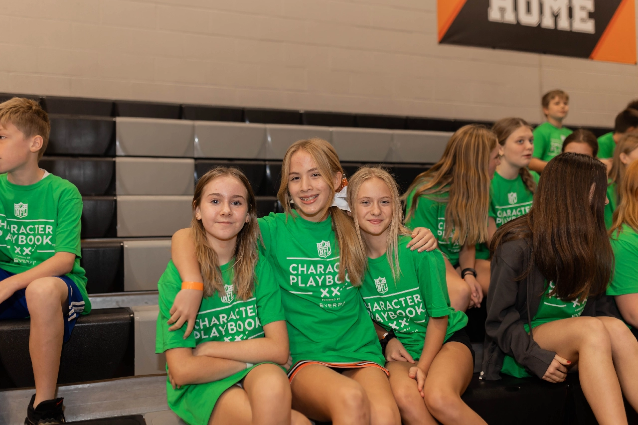 Students smiling while sitting together in bleachers