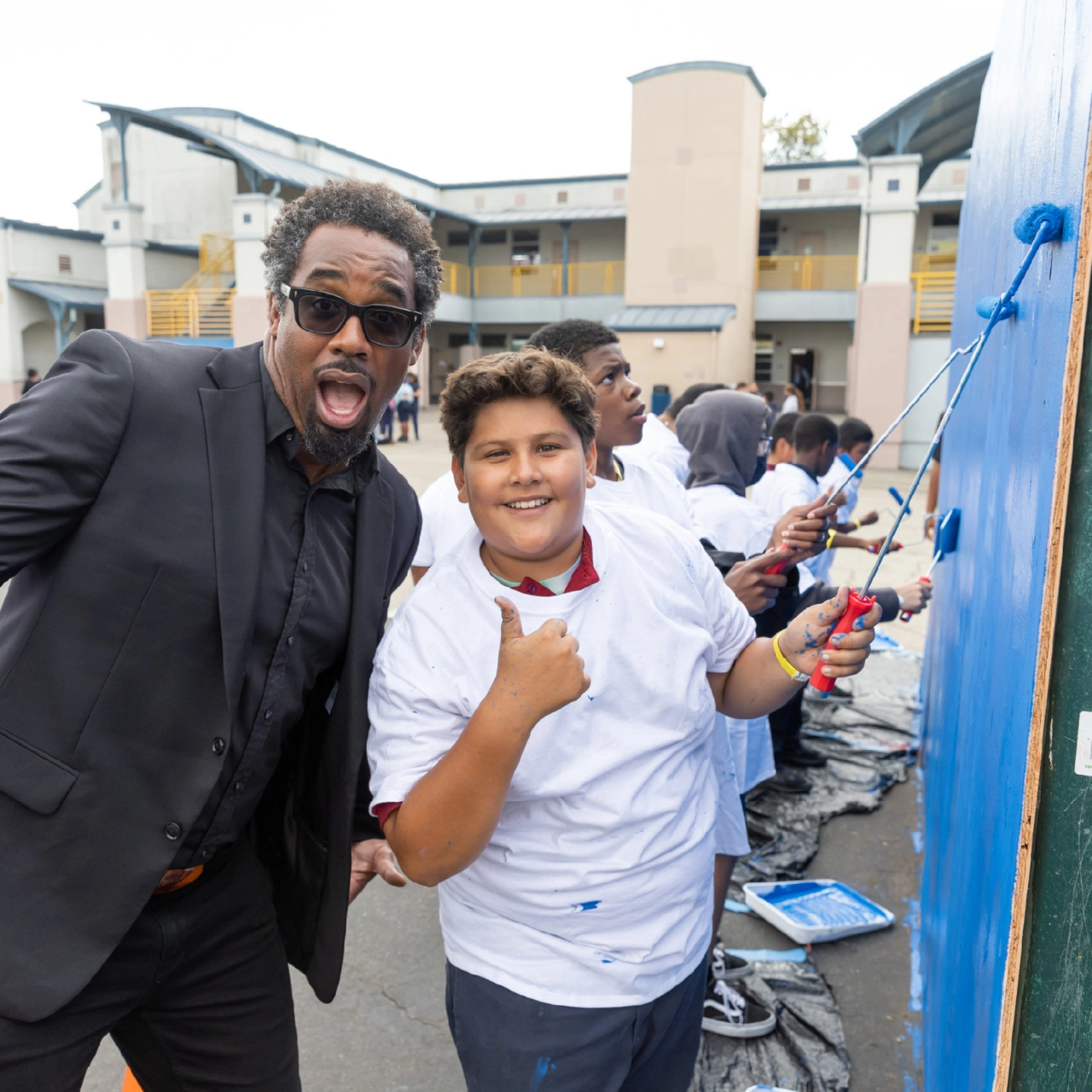 NFL Player positing with student during community beautification project