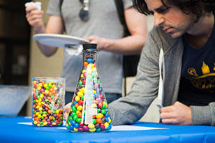 Student estimating amount of candy in beaker