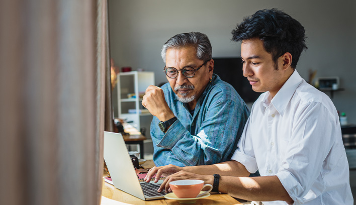 two people looking at a laptop