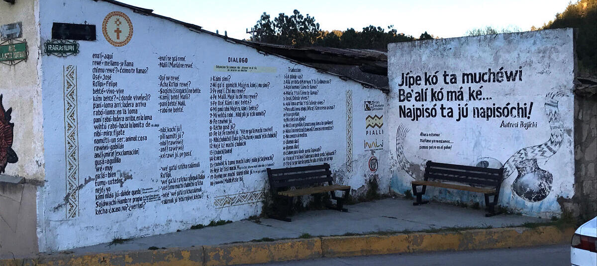 Wall with Rarámuri words against a sunset