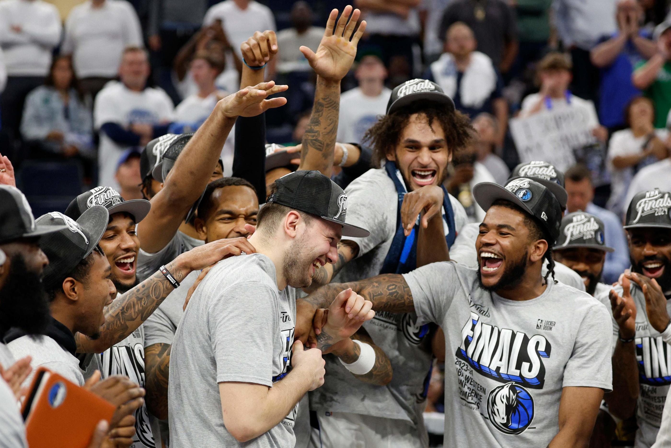 Luka Doncic félicité par ses coéquipiers après un nouveau match de grande classe et une victoire qui qualifie Dallas pour les finales NBA. David Berding/Getty Images/AFP