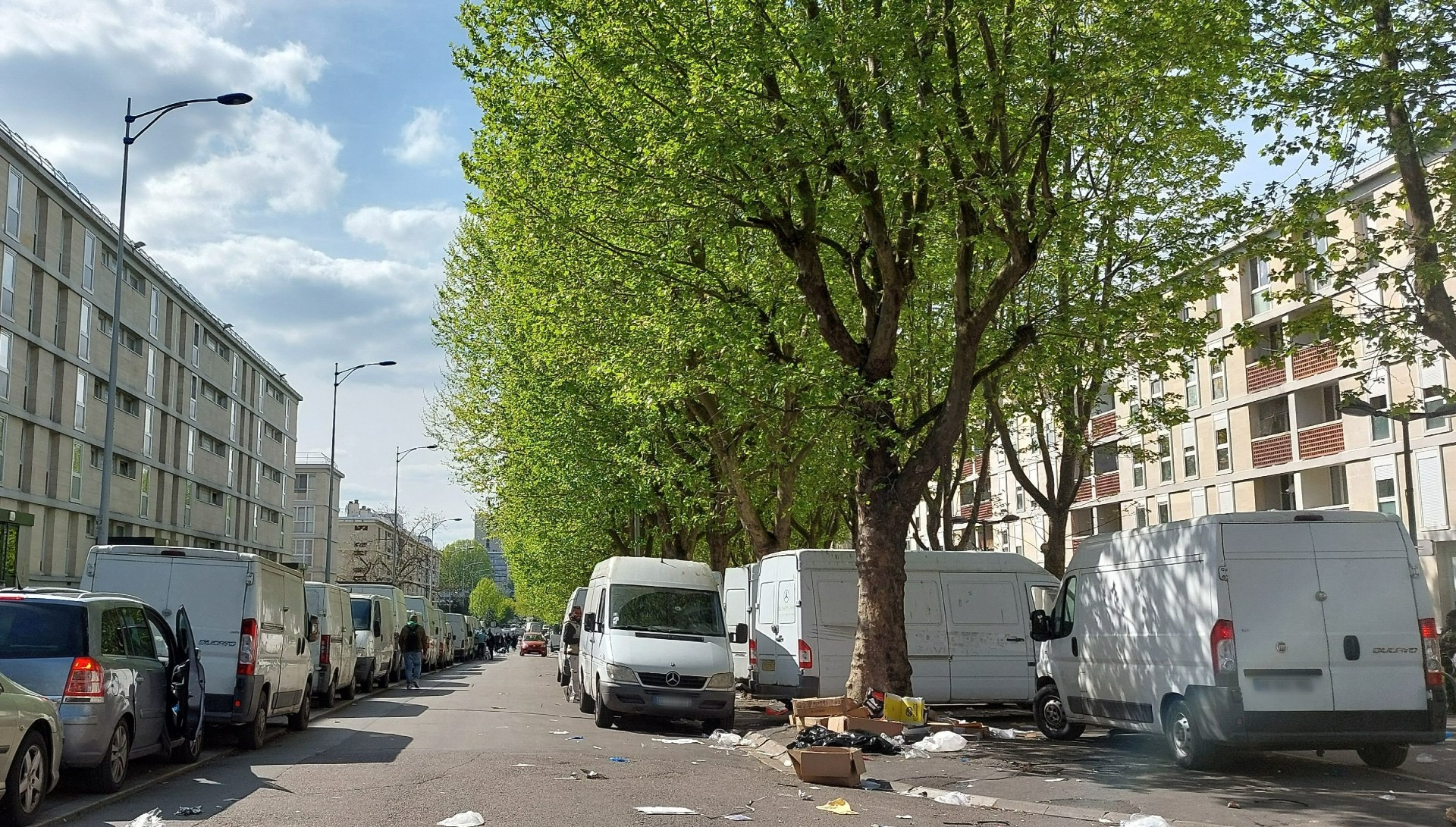 Abords du marché de Sarcelles (Val-d'Oise), le 25 avril. Des fourgonnettes et autres vieilles voitures délabrées, sans assurance ni contrôle technique, squattent les places de parking mais aussi des espaces théoriquement réservés aux piétons.