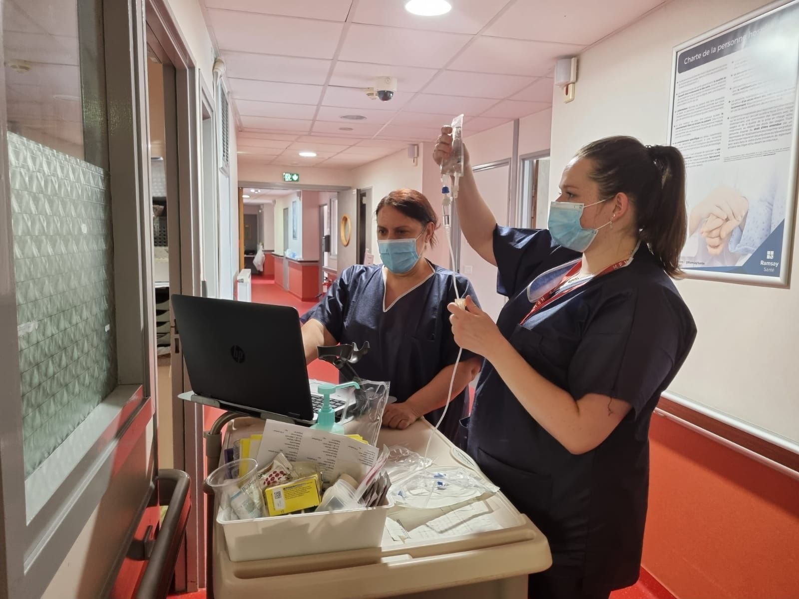 Bry-sur-Marne, ce lundi. Mélanie (à droite) prépare une perfusion dans les couloirs de l'hôpital, aux côtés de Farida.