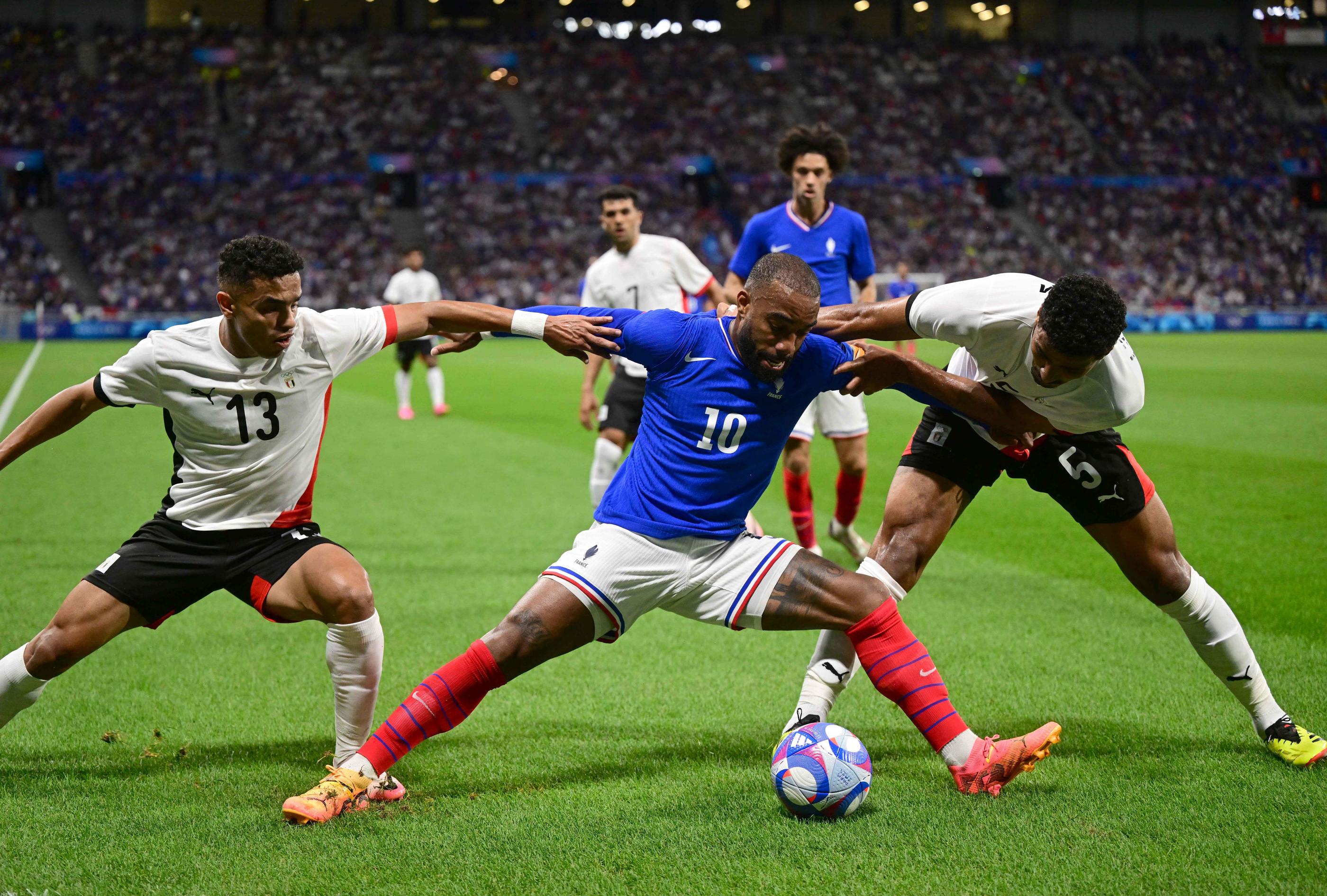 Alexandre Lacazette cerné par deux Egyptiens. AFP.