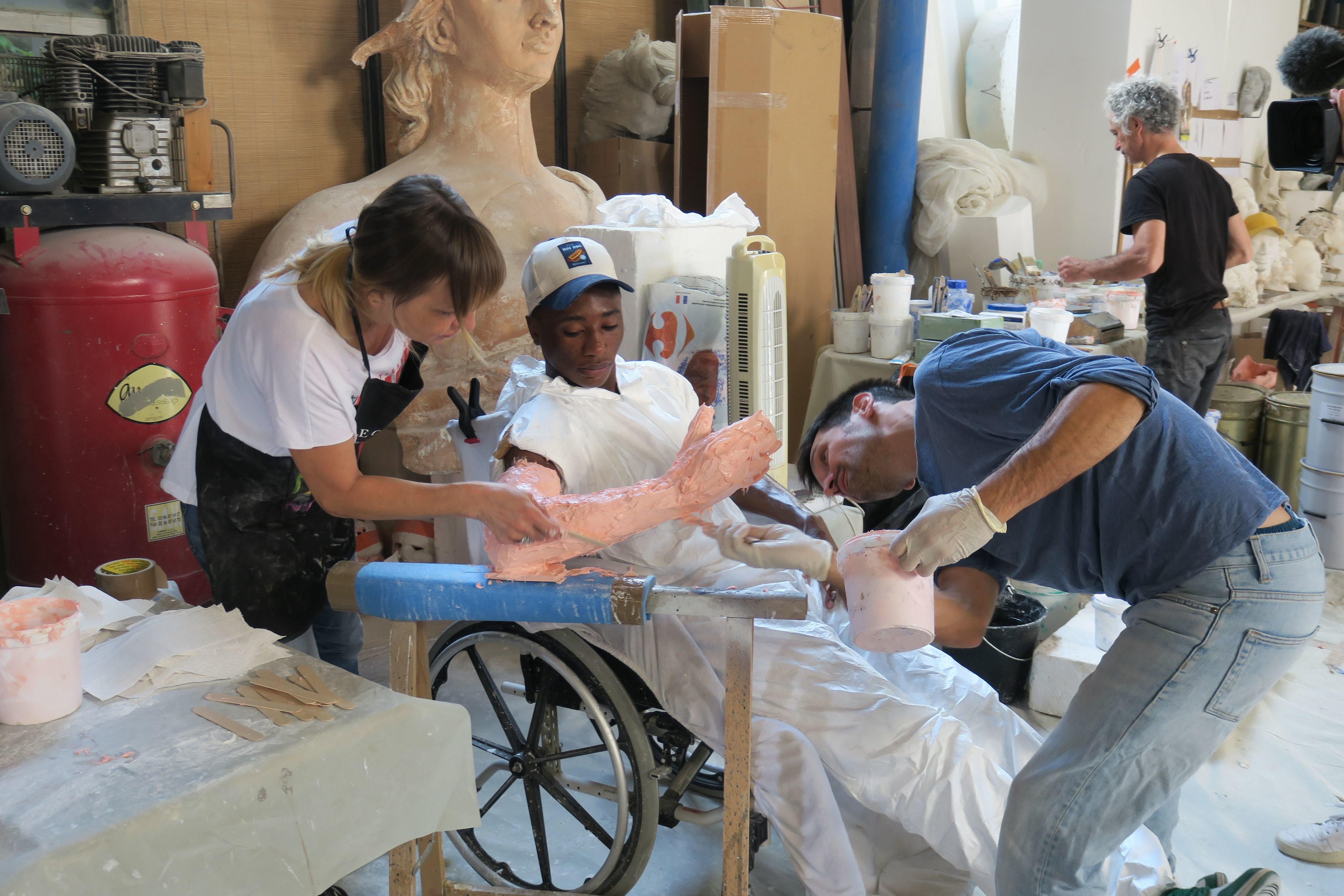 Saint-Denis, le 12 juillet. Le sculpteur et plasticien Ugo Schiavi (en bleu) crée une œuvre de 150 mètres de long pour le Village olympique constituée des moulages des corps d'habitants du quartier. LP/C.G.