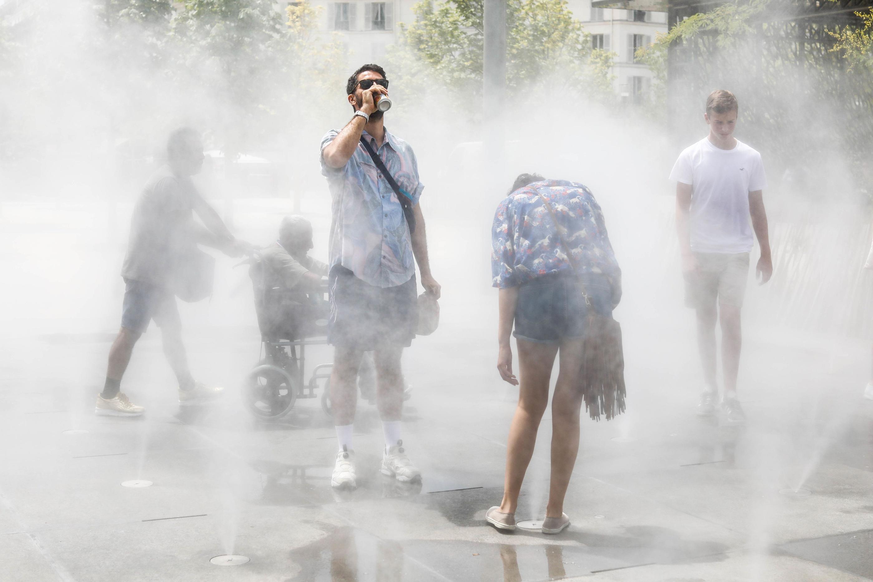 Paris Ier, le 4 juillet 2018. Pour échapper à la chaleur et à la fatigue qu'elle provoque, des Parisiens et touristes se sont réfugiés dans le parc Nelson Mandela des Halles où des brumisateurs rafraîchissent l'air. LP/Olivier Corsan