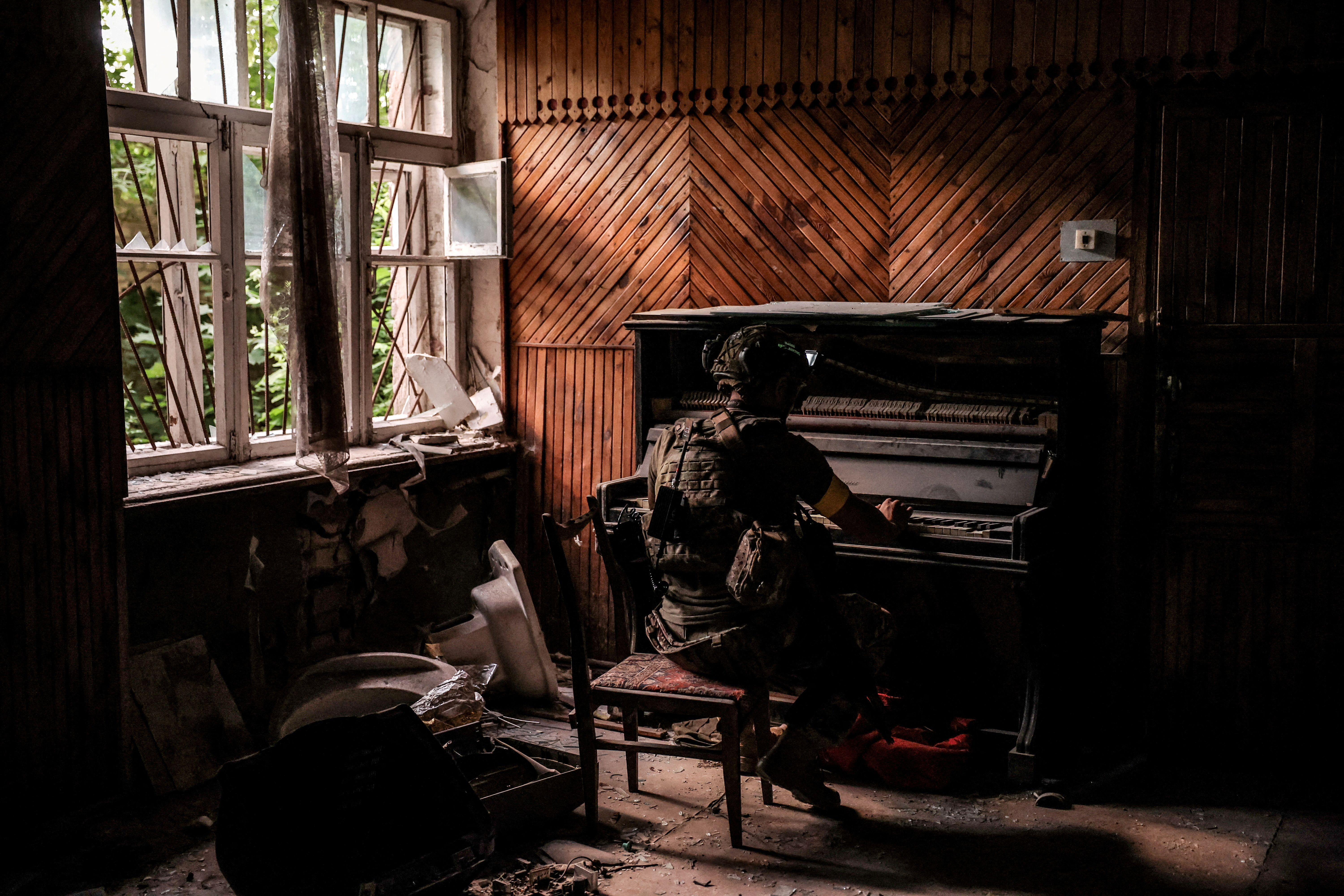 A Ukrainian serviceman plays a piano in a damaged building in the frontline town of Chasiv Yar