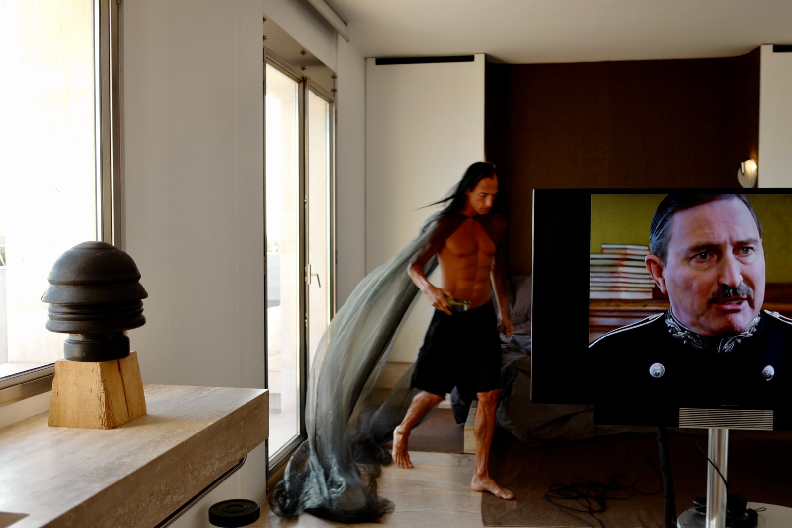 Agatha Christies Poirot plays on the swivelable floating television in front of Owenss platform bed.