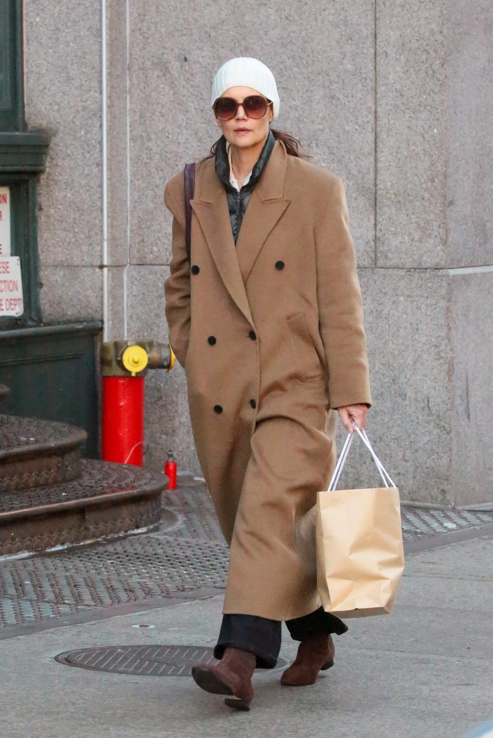 Inizio gennaio 2024 a New York Katie Holmes abbina gli stivali marroni a pantaloni neri cappotto XXL e gilet in piuma.