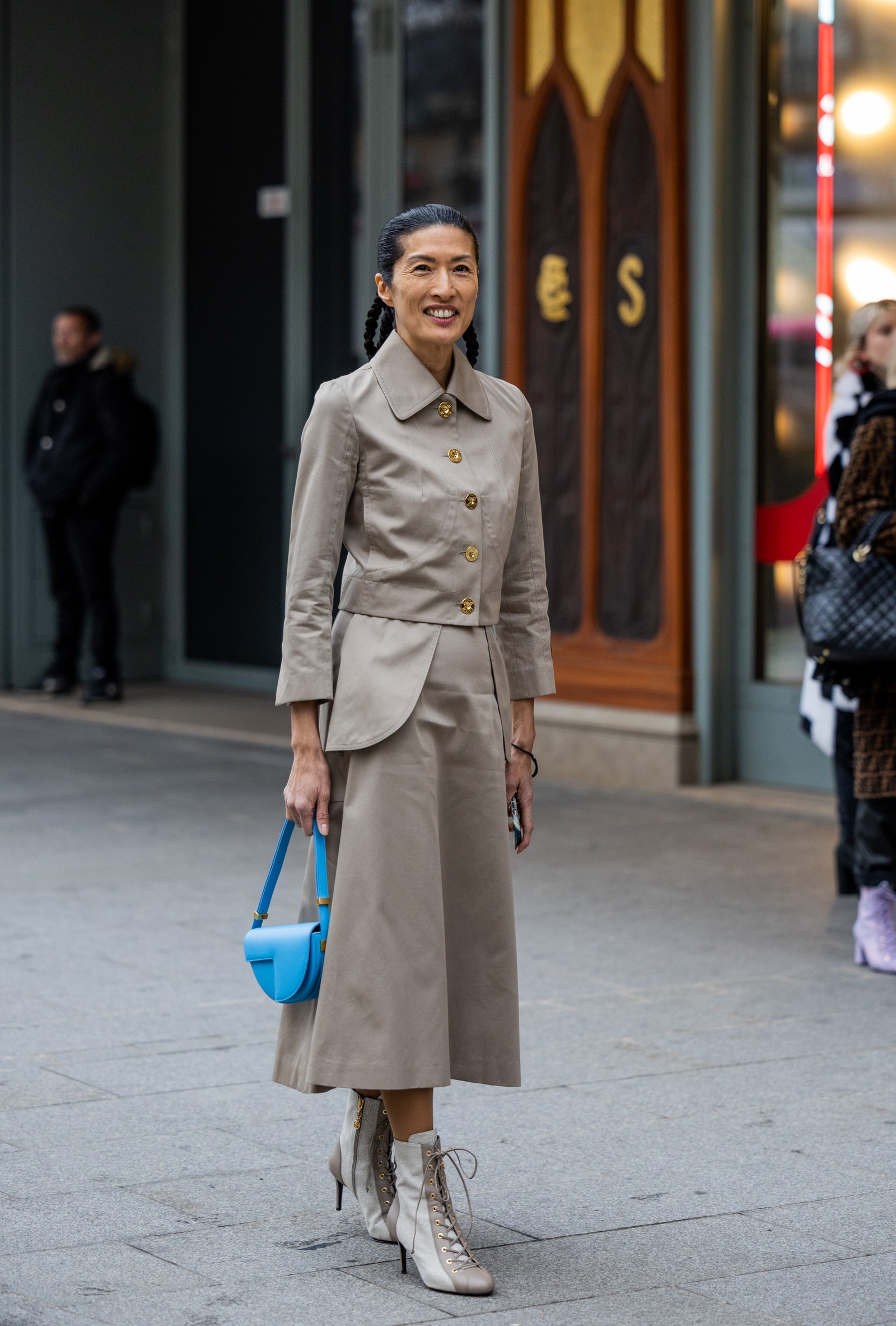 PARIS FRANCE  JANUARY 27 Suzi de Givenchy wears beige button up jacket mid skirt blue bag laced boots outside Patou at...