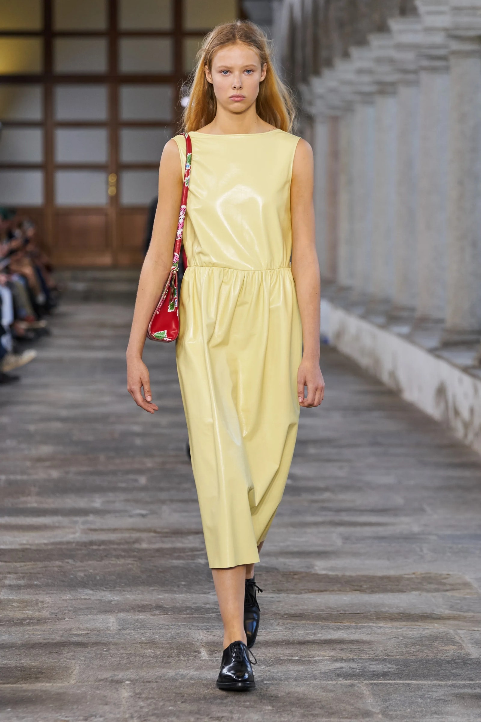 Modelo luce un vestido amarillo de cuero con zapatos Oxford en Bally PrimaveraVerano 2024.