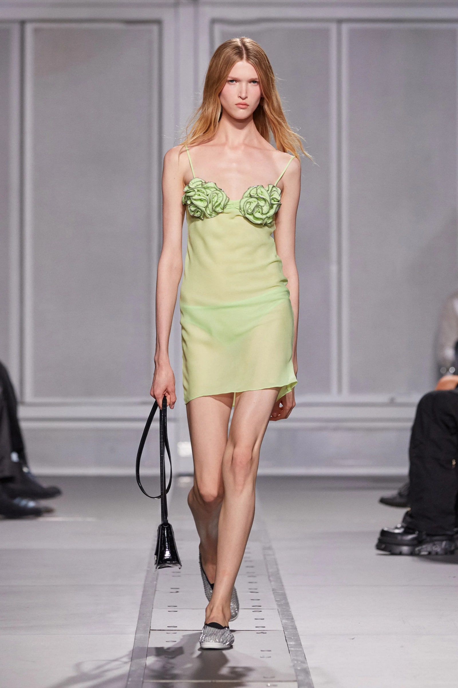 Modelo luce un vestido verde pastel con zapatos planos en Coperni PrimaveraVerano 2024.