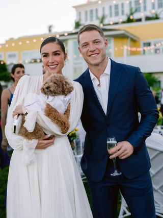 Image may contain Christian McCaffrey Olivia Culpo Blazer Clothing Coat Jacket Formal Wear Suit Face and Head