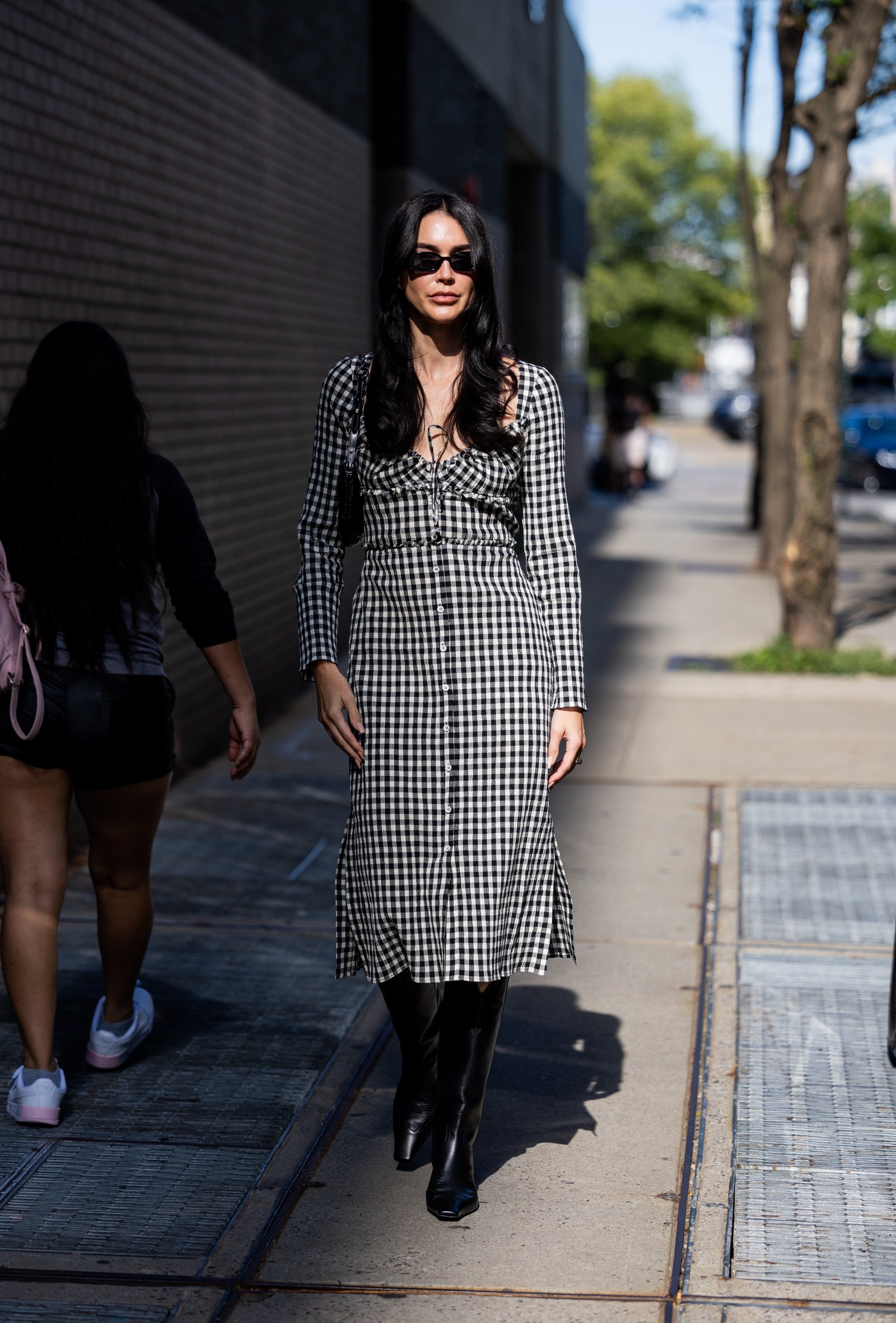 NEW YORK NEW YORK  SEPTEMBER 10 Brittany Xavier wearing black white checkered dress black boots outside Altuzarra on...