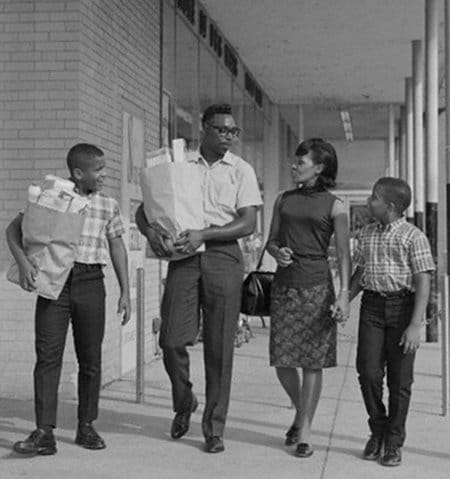 Vintage African American black family walking out of grocery store shopping.