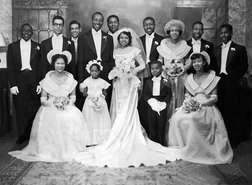 A vintage photo of a wedding party posing for a picture.