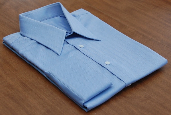 A dress shirt on a wooden table.