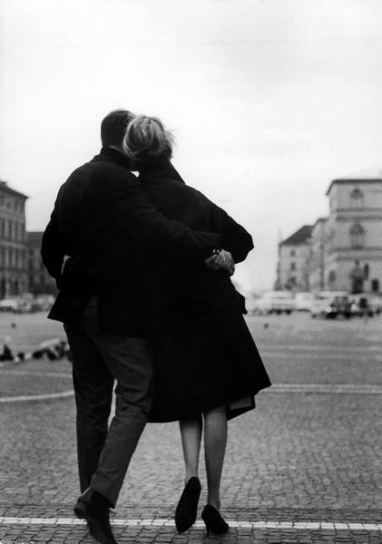 A black and white photo capturing a couple strolling through a city, offering a DIY perspective on marital bliss.