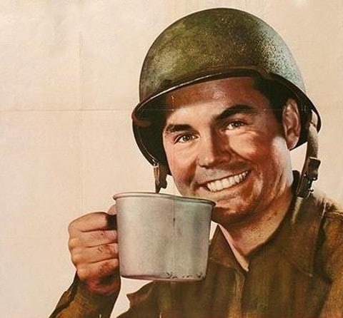 A man in a military uniform is holding a perfect cup of coffee.