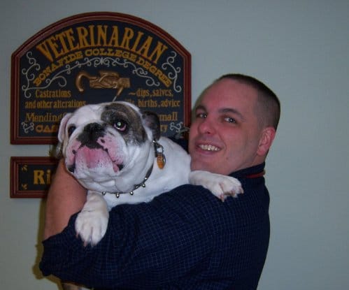 A veterinarian holding a bulldog.