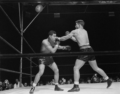 Two men in a boxing ring engaging in a punching battle.