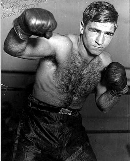 A boxing aficionado captured a striking black and white photo, highlighting the raw intensity of a man in boxing gloves as he showcases impeccable punching combinations. This captivating image showcases the essence of boxing,