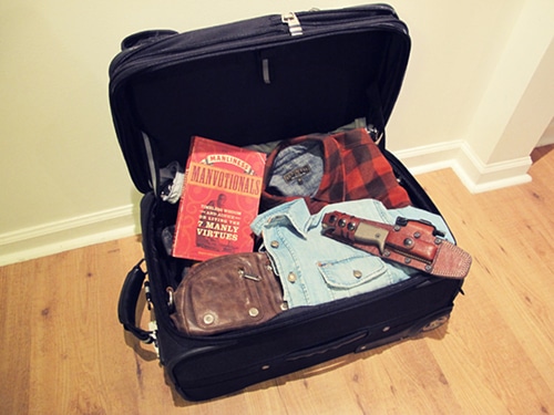 A knife holster in a suite case with a book.