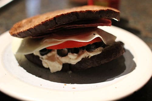 A Month of Sandwiches featuring Great-Grandpa's Salami Sandwich, served on a plate with meat and cheese.