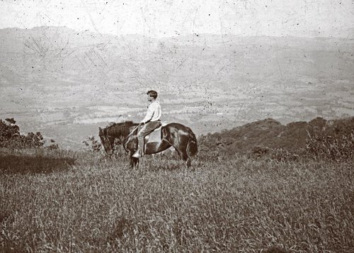 Jack London riding the horse in the field. 