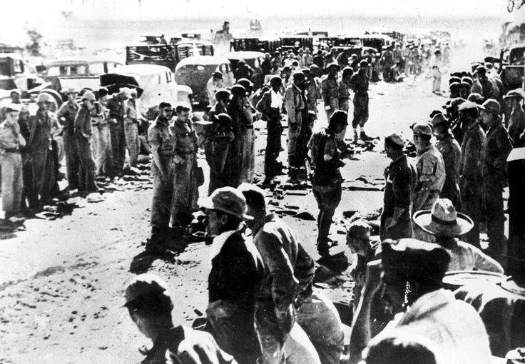 A group of people, including a man, standing in a line on a dirt road.