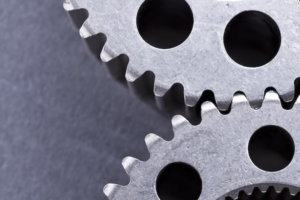 Close-up of interlocking metal gears with sharp, fit teeth.