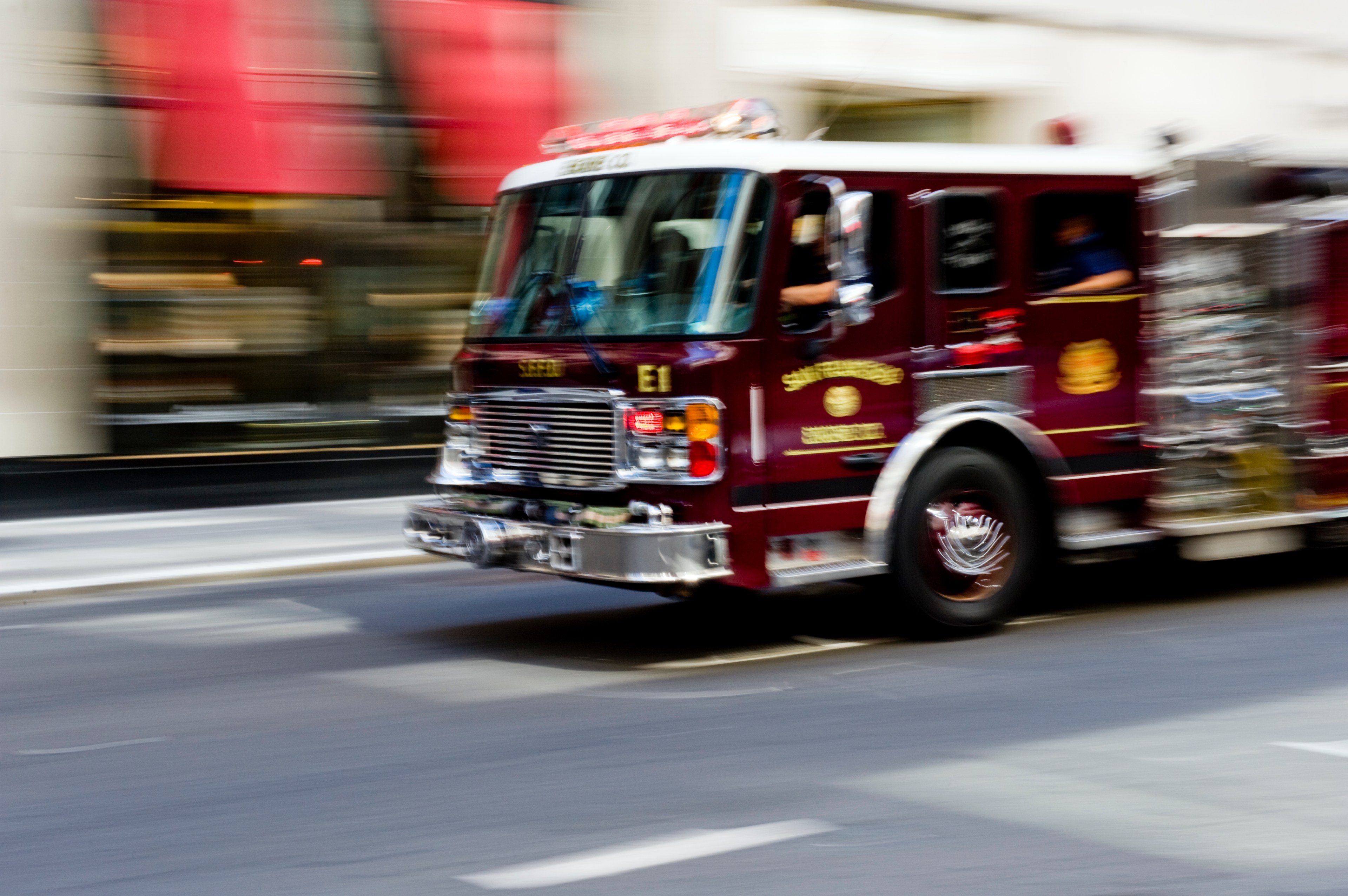 A fire truck races down a street.