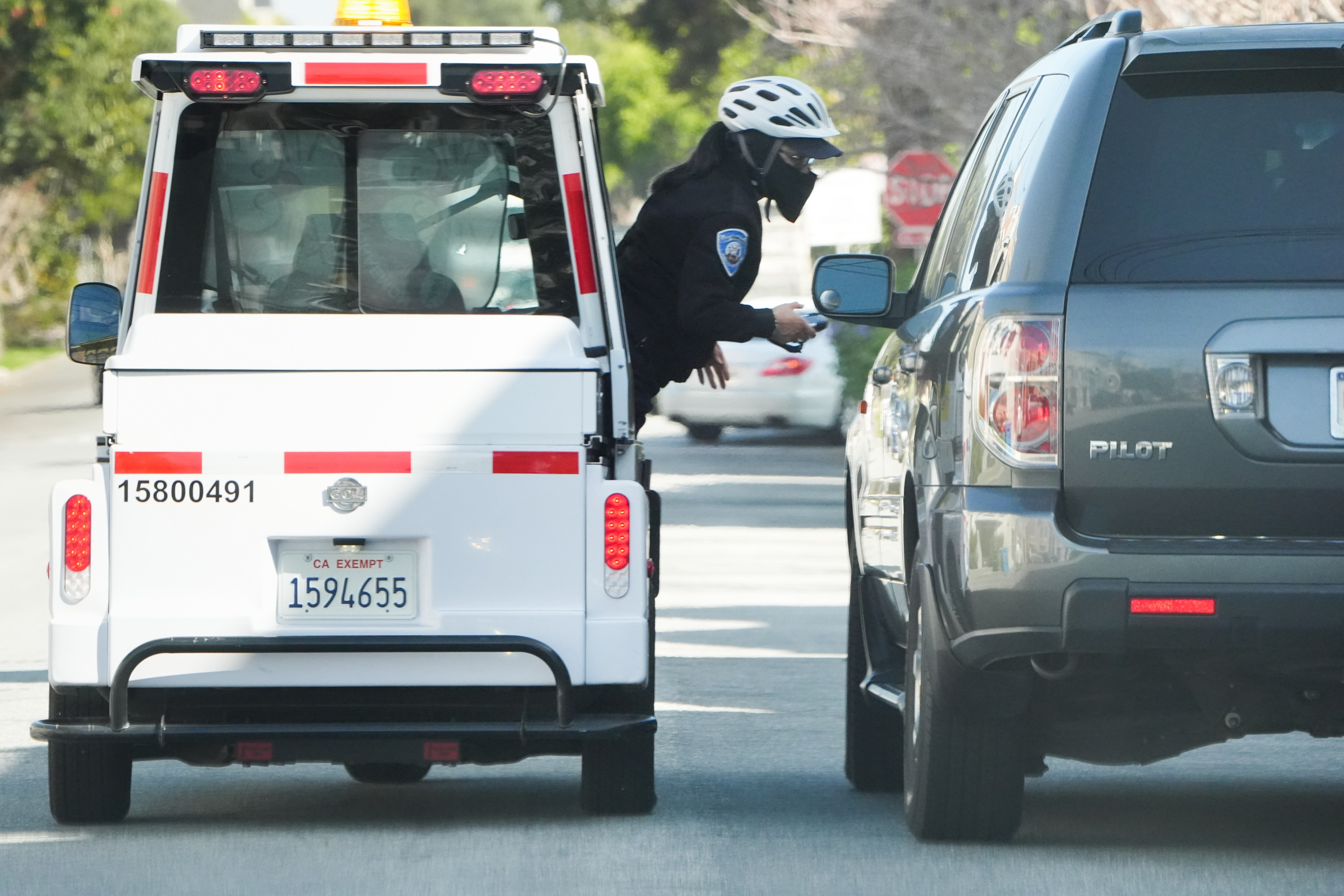 A parking control officer places a ticket on an SUV.