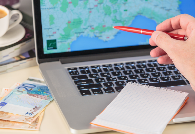 Traveler looking at a map with money