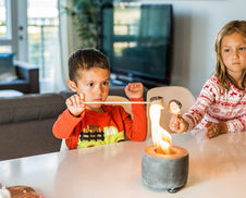 Kids toasting marshmallows on National Marshmallow Toasting Day. 