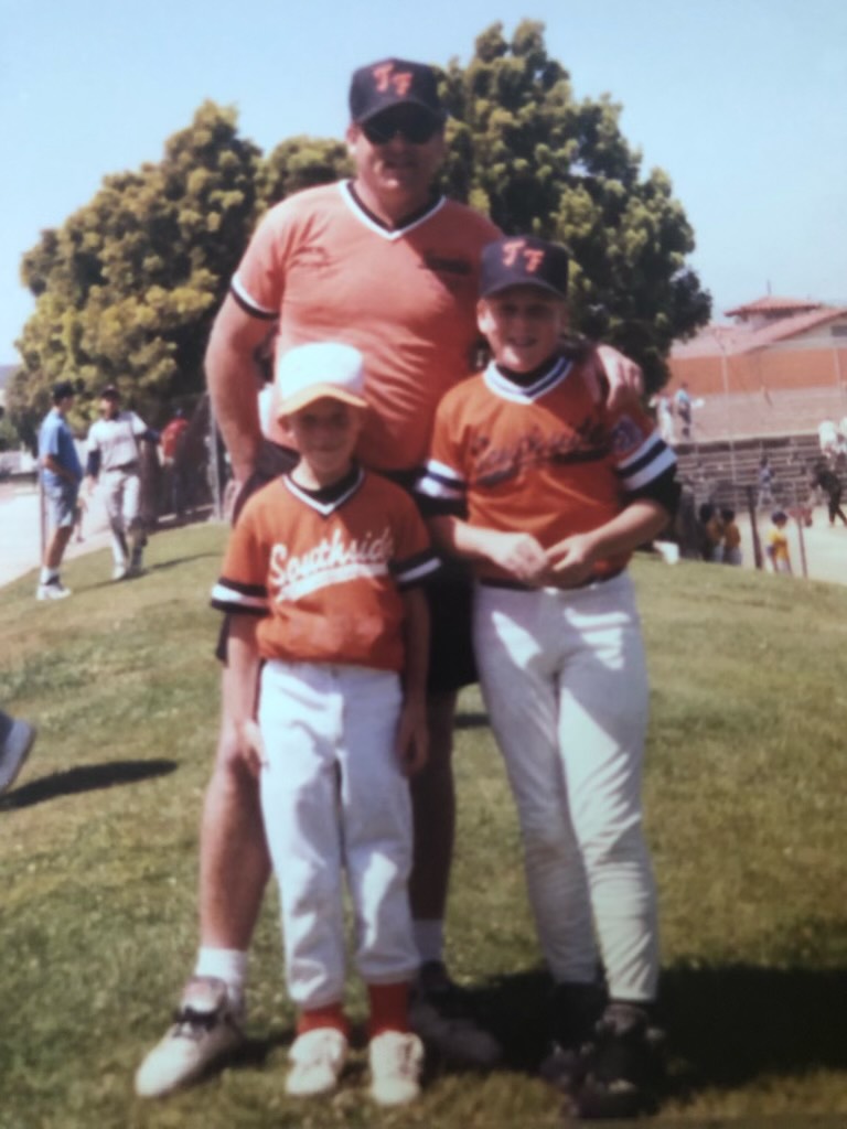 Brothers Dustin and Jason Kelly pose in their Southside Little League uniforms with their dad Mike.