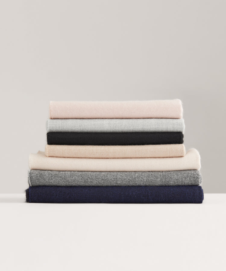 Stack of folded blankets on a white surface