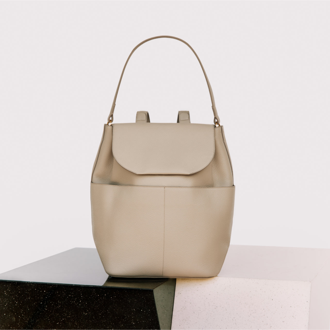 Handbag placed on a geometric block surface.