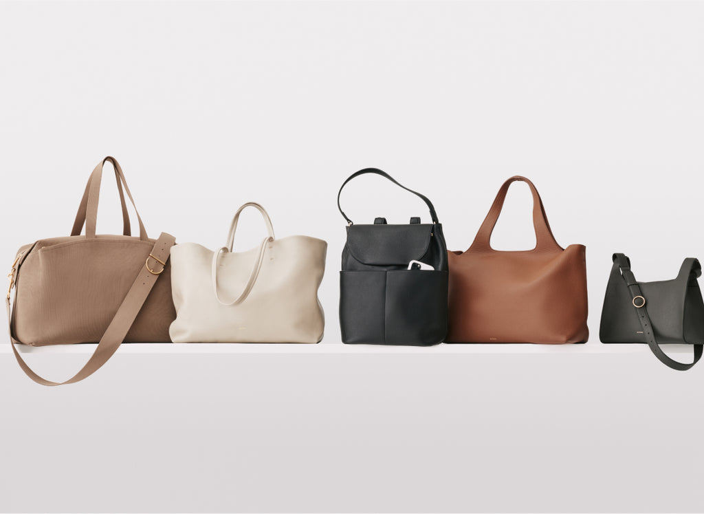 Five different styles of handbags placed in a row.