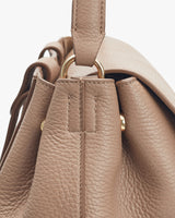 Close-up view of a handbag's top handle and ring connector.