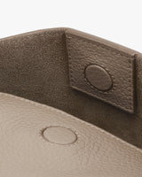 Close-up of a bag with a flap and snap button closure.