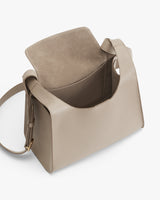 Open handbag with flap top and shoulder strap, standing upright.