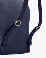 Close-up of a handbag with a shoulder strap and metal rings.